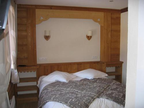 La ferme de sixt chambre proche La Clusaz et Grand Bornand في سان جان دو سكست: غرفة نوم بسرير مع جدار خشبي