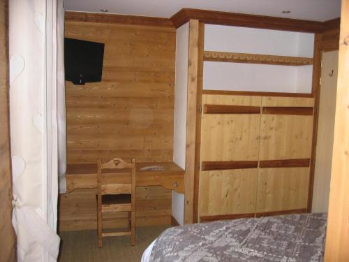 a bedroom with a bed and a desk and a television at La ferme de sixt chambre proche La Clusaz et Grand Bornand in Saint-Jean-de-Sixt