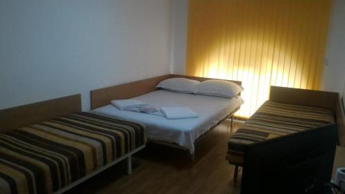 a small bedroom with a bed and two beds sidx sidx sidx at Hostel Ruschuk in Ruse