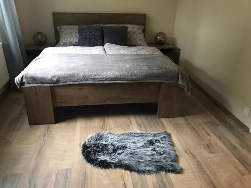 a bedroom with a bed with a furry rug on the floor at Apartmány Gryf Harrachov in Harrachov