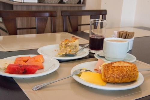 a table with two plates of food and a cup of coffee at Pousada Espindola in Penha