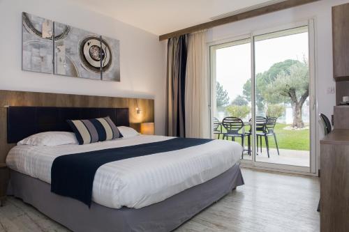 a bedroom with a large bed and a large window at Le Domaine des Oliviers in Pierrelatte