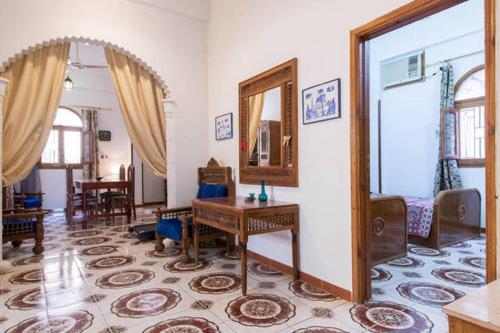 a living room with a table and a mirror at Terrasses et Jardins sur le Nil chez Hagag rive Ouest in Luxor