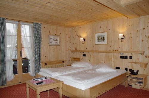 a bedroom with a large bed in a wooden room at Posthotel Rössli in Gstaad