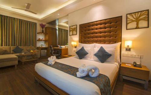 Un dormitorio con una cama grande con dos animales de peluche. en Hotel Riverview, en Ahmedabad