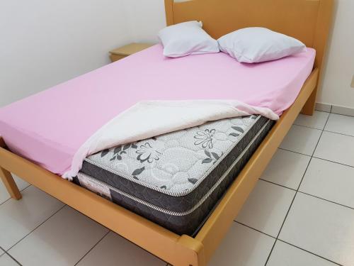 Una cama con dos almohadas encima. en Residencial Júnior, en Bombinhas