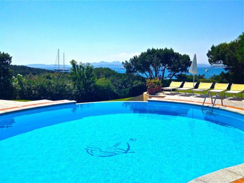 una piscina con sillas y vistas al océano en Hotel Capriccioli en Porto Cervo