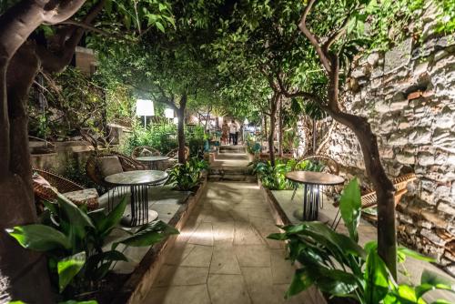 Un jardín con mesas, sillas y árboles. en Médousa Bistrot & Suites, en Taormina