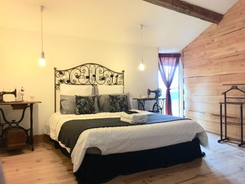 ein Schlafzimmer mit einem großen Bett und einer Holzwand in der Unterkunft Magnificent Renovated Farmhouse - 10 Min A7 - in Anneyron