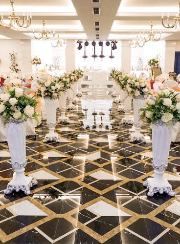 a row of vases filled with flowers on a dance floor at Canh Hung Palace in Hai Phong