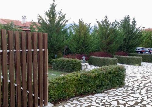 een houten hek in een tuin met struiken en bomen bij villa in Parnassos in Arachova