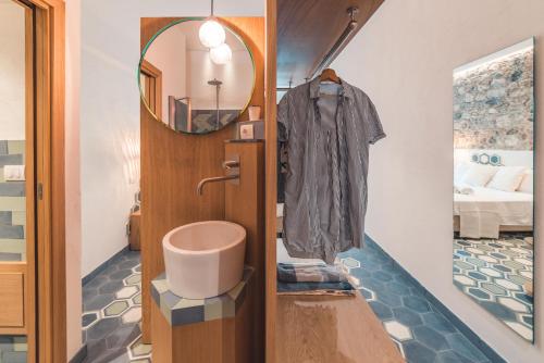 bagno con lavandino e specchio di Médousa Bistrot & Suites a Taormina