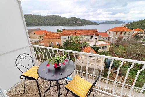 a balcony with a table and chairs and a view of the water at Apartments Nodilo in Polače