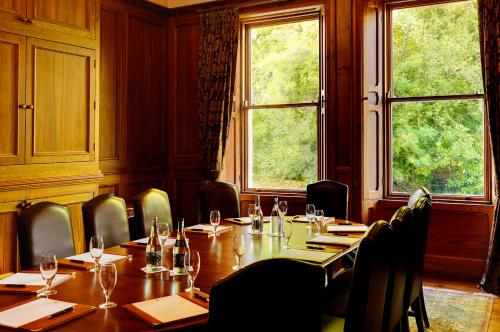 a dining room with a table and chairs and windows at Mount Falcon Estate in Ballina