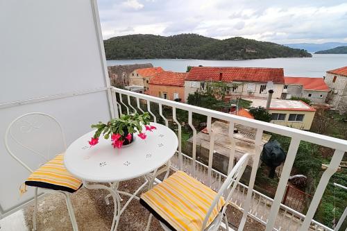 a balcony with a table and chairs and a view of the water at Apartments Nodilo in Polače