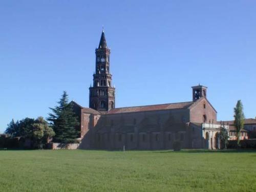 a large building with a clock tower in a field at Hotel Majestic in San Giuliano Milanese