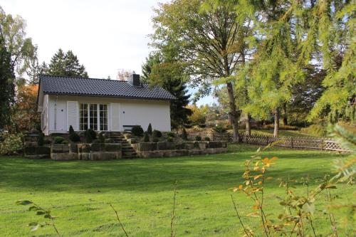 ハーネンクレー・ボックスヴィーゼにあるGipfel-Glückの緑の芝生のある庭の白い家