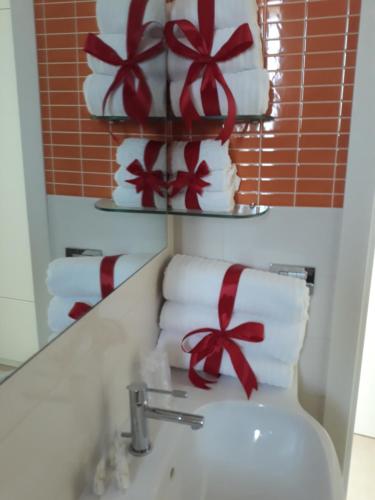 ein Bad mit einem Waschbecken und Handtüchern mit einer Schale darauf in der Unterkunft Cuoreverde Matera in Matera