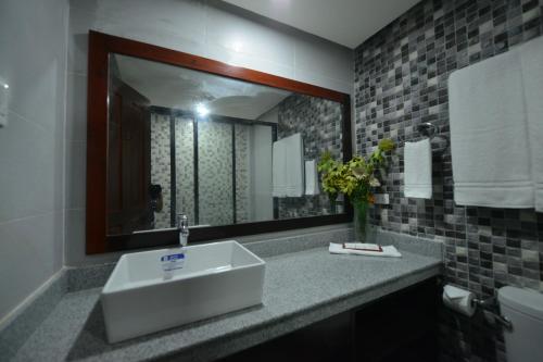 a bathroom with a sink and a mirror at Hotel Gabriella in Tagbilaran City