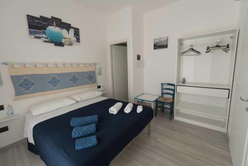 um quarto com uma cama azul e branca e uma casa de banho em Giglio Marino em Tortolì