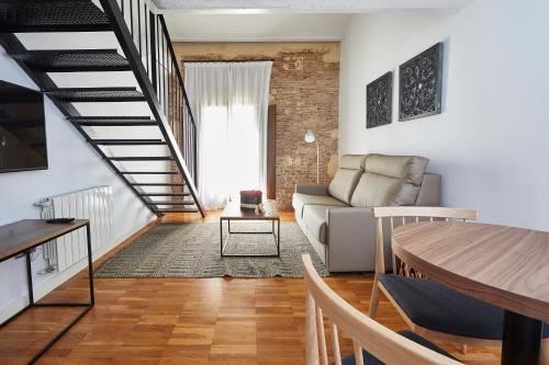 a living room with a couch and a staircase at Alqueria de Vilches in Cullera