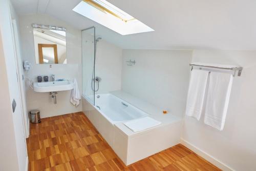 a white bathroom with a tub and a sink at Alqueria de Vilches in Cullera