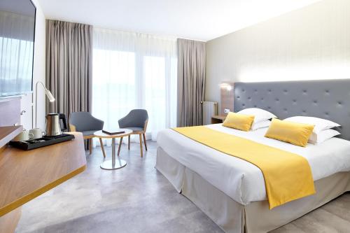 a hotel room with a large bed with yellow sheets at Atlanthal in Anglet