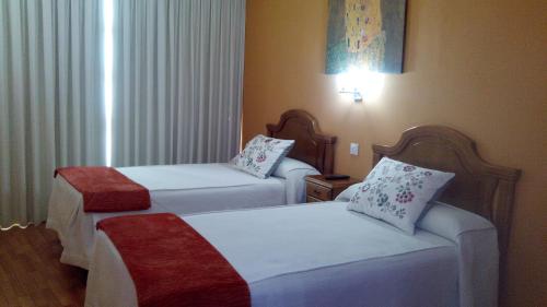 a hotel room with two beds in a room at Apartamentos Casa Rosendo in Cangas del Narcea