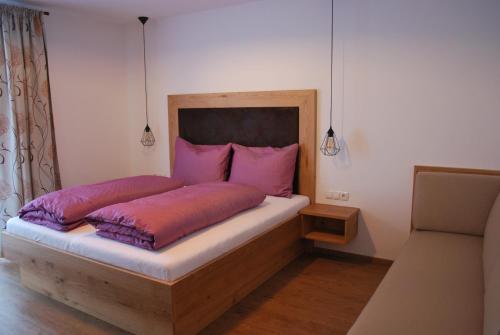 a bedroom with a bed with pink pillows at Die Atempause - appartements in Flachau