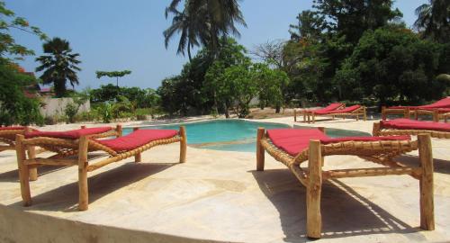 a group of chairs sitting next to a swimming pool at Panga Chumvi Beach Resort in Matemwe