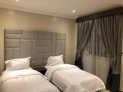 2 letti posti uno accanto all'altro in una camera da letto di Rose Niry Hotel Suites روز نيري للاجنحة الفندقية a Al Khobar