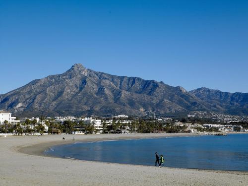 a man standing on top of a beach next to a lake at Benabola Hotel & Suites in Marbella