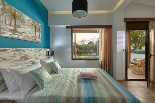 Un dormitorio con una cama con paredes azules y una ventana. en Villa Feronia, en Hersonissos