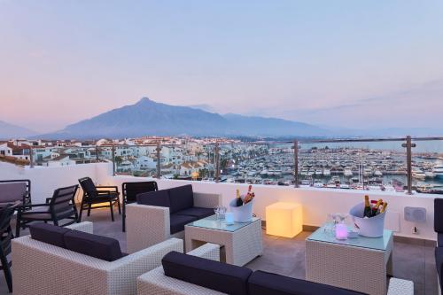 a rooftop patio with furniture and a view of a city at Benabola Hotel & Suites in Marbella