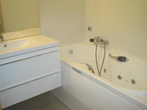 Baño blanco con bañera y lavamanos en Le Cristal 2, en Les Gets