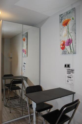una habitación con 2 mesas y sillas y un cuadro en la pared en BCN Condal Hostal, en Barcelona