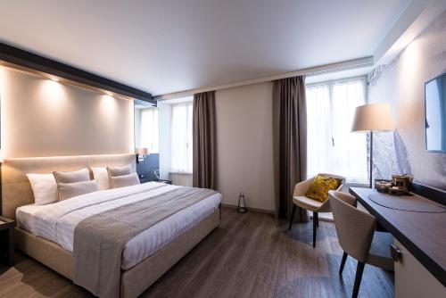 a hotel room with a bed and a desk at Ambassador Boutique Hotel in Nyon