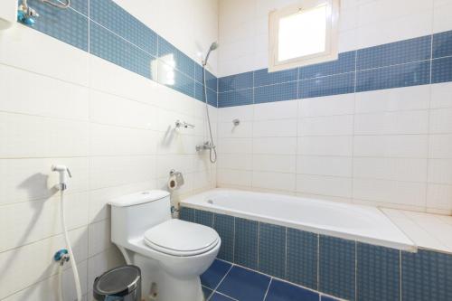 a bathroom with a toilet and a bath tub at High House in Sharurah