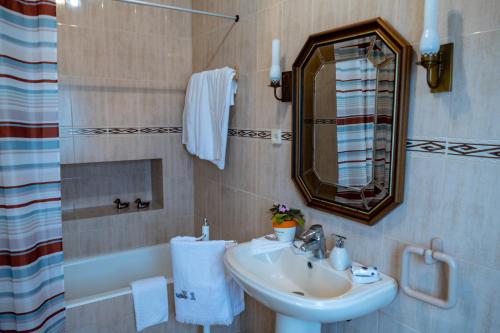 a bathroom with a sink and a mirror and a tub at Quintal d'Angra in Angra do Heroísmo