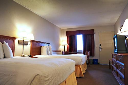 a hotel room with two beds and a flat screen tv at Atlantis Inn in Rehoboth Beach