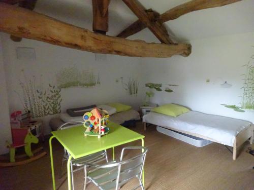 a room with a bed and a table and chairs at Gîte au Martin Pêcheur in Laiz