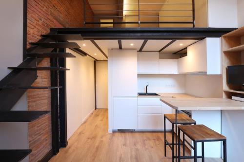 une cuisine avec une mezzanine aménagée avec une table et des tabourets dans l'établissement Riverside Toulouse (Renaissance), à Toulouse