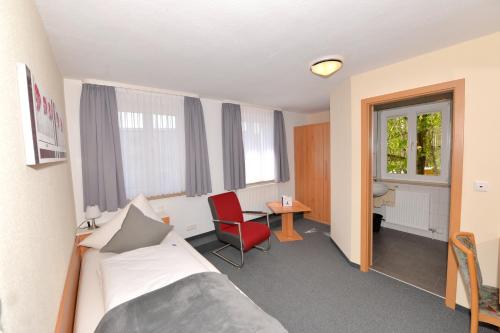 a hotel room with a bed and a desk and window at Gasthof Kolb in Bayreuth