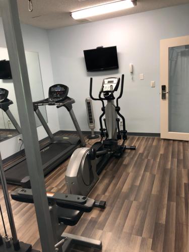 a gym with two exercise bikes and a flat screen tv at Baymont by Wyndham Kokomo in Kokomo