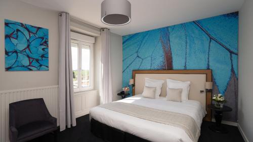 een slaapkamer met een bed en een blauwe muur bij le tisseur des saveurs in Panissières