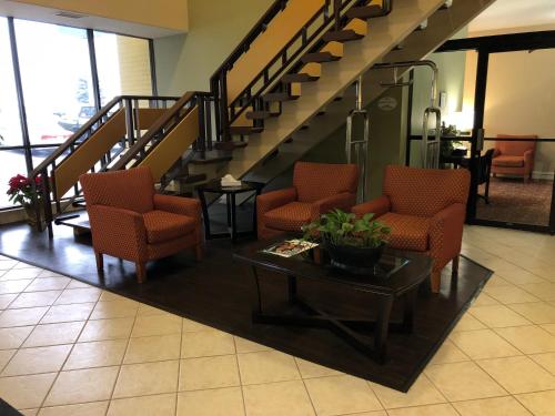 a lobby with chairs and a table and stairs at Baymont by Wyndham Kokomo in Kokomo