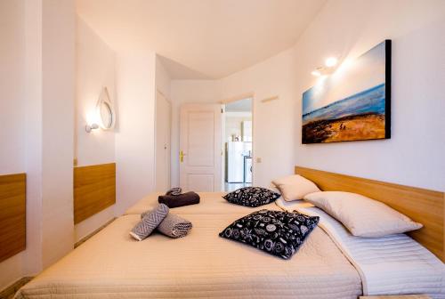 a large bed in a room with two pillows on it at Los Cristianos Guayero apartment in Los Cristianos