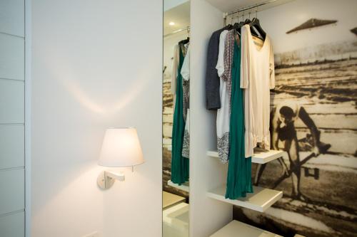 a dressing room with a lamp and clothes on racks at Hotel Majestic in Milano Marittima