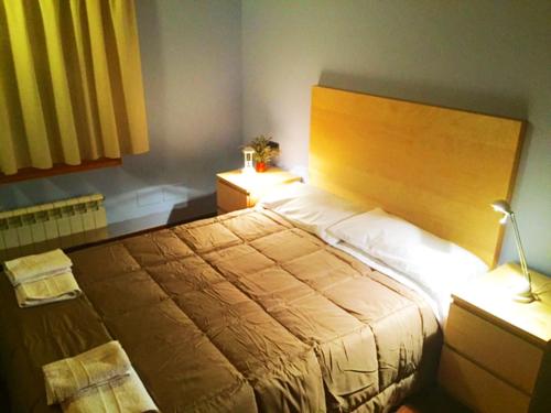 a bedroom with a large bed and two night stands at Casa PereCampelles - Vall de Núria - Ripollès in Campelles