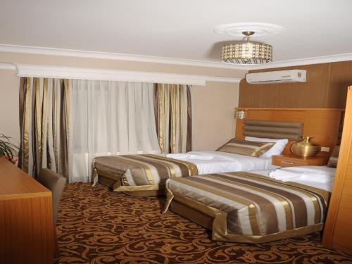 A bed or beds in a room at Alfa Hotel